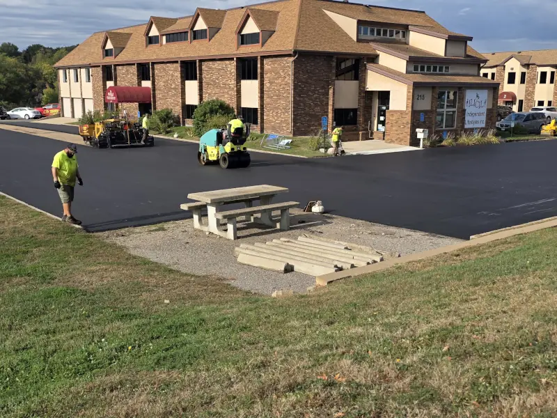 Asphalt being installed and compacted on parking lot.